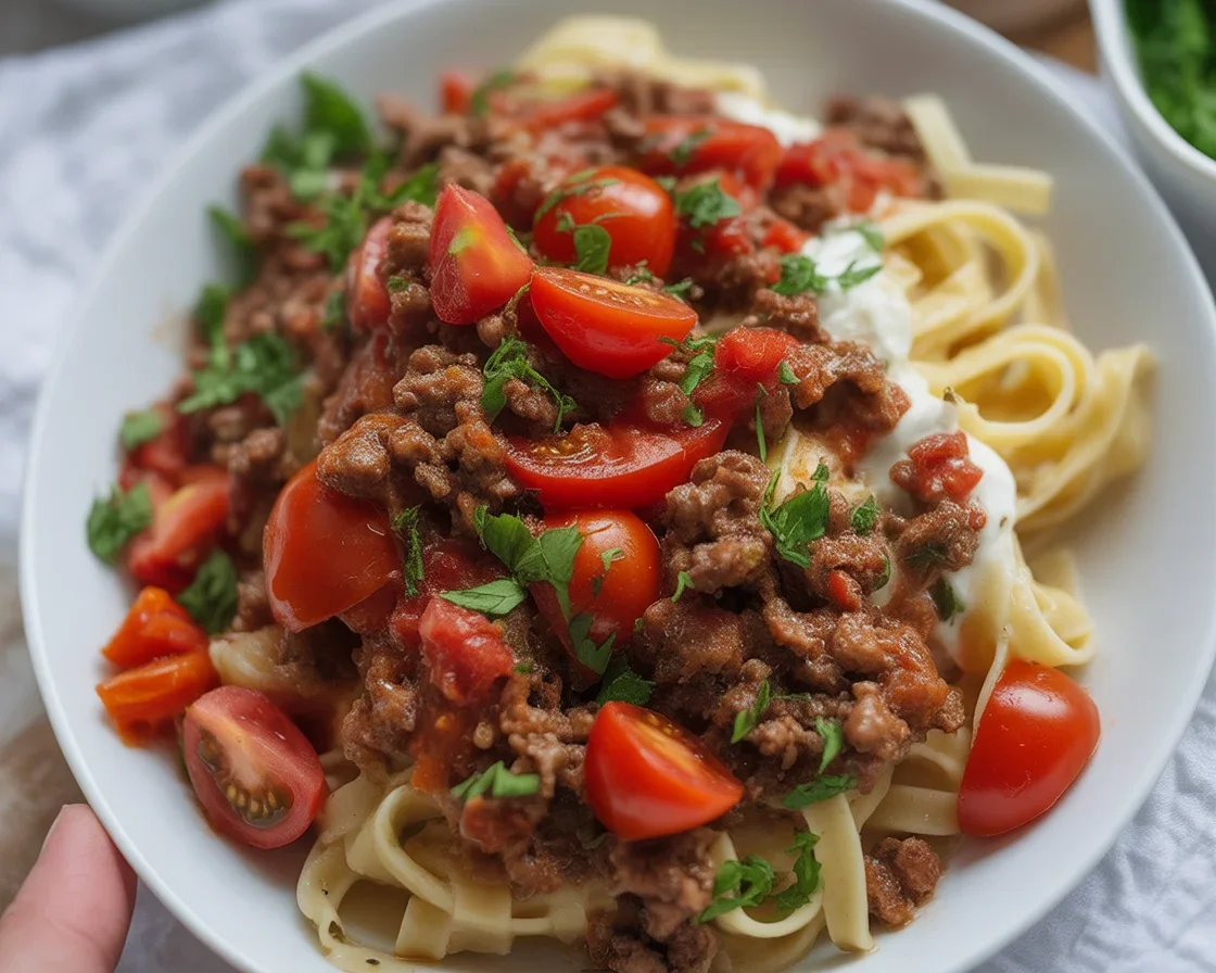 A bowl of Anna Paul's Viral Turkish Pasta topped with spiced beef and garlic yogurt.