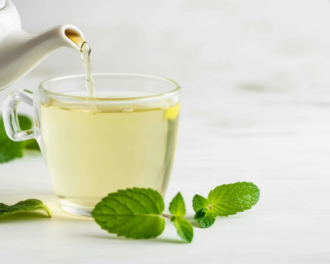 Lemon balm drink for weight loss with fresh lemon balm leaves and lemon slices.